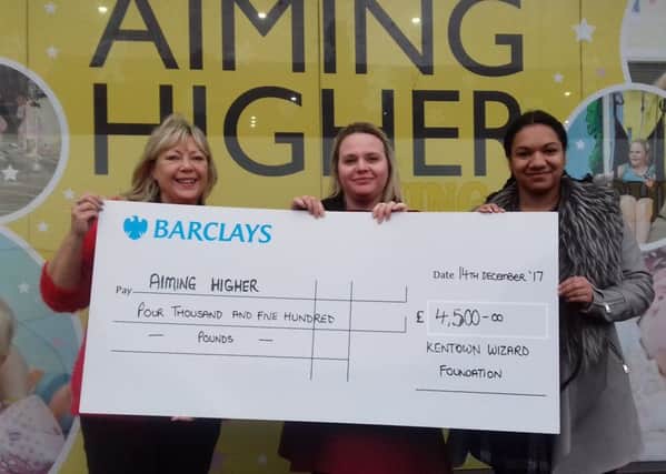 Debbie Bamber hands over the money to Claire Bradley, project manager, and Latoya Sykes from Aiming Higher