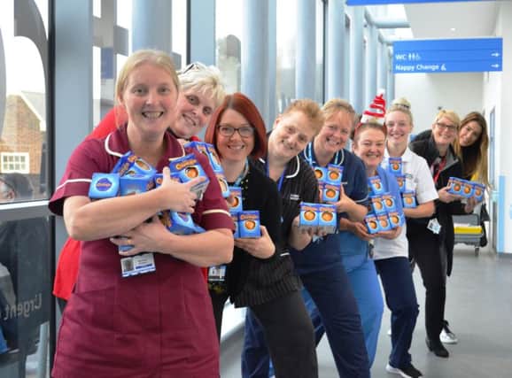 Staff receive boxes of Chocolate Oranges from Department of Work and Pensions staff, Ellie Emmett and Holly Kneale, pictured at the end of the line