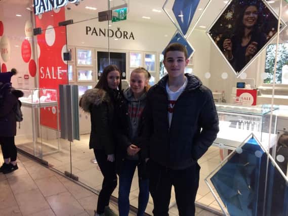 Tiegan Holmes, Amy Collier and Luke Johnson waiting to go into the Pandora Store at the Houndshill shopping centre Blackpool on Boxing Day