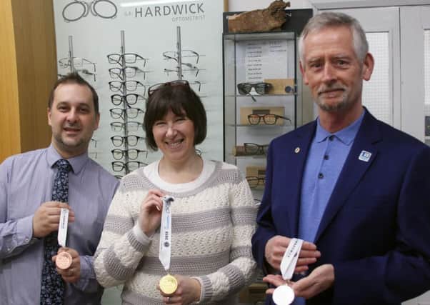 Elizabeth Dee admires the new medals with Drew Thompson of GR Hardwick (left) and Lions president Roger Franklin