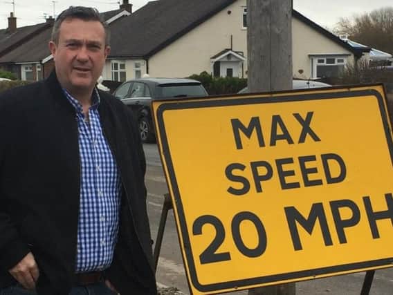 Coun Jason Roberts with one of the signs which has been installed on Midgeland Road