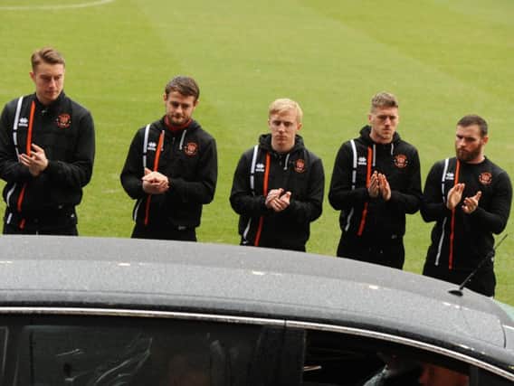 Blackpool players applaud as the the Jimmy Armfield funeral cortege passes inside the Bloomfield Road stadium
