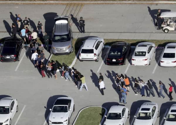 Students are evacuated by police from Marjory Stoneman Douglas High School in Parkland, Fla., on Wednesday, Feb. 14, 2018, after a shooter opened fire on the campus. (Mike Stocker/South Florida Sun-Sentinel via AP)