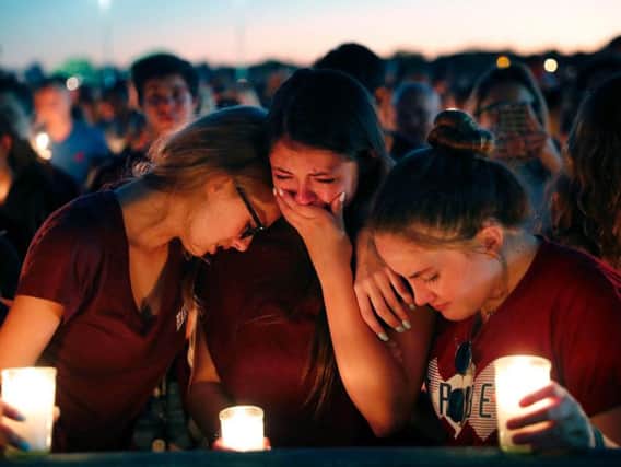 Some people openly sobbed as the victims' names were read aloud at the vigil near the school in Parkland on Thursday night.
