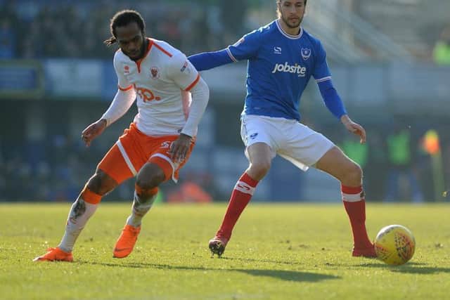 Nathan Delfouneso battling with Pompey defender Christian Burgess, whose mistake led to Blackpool's opener