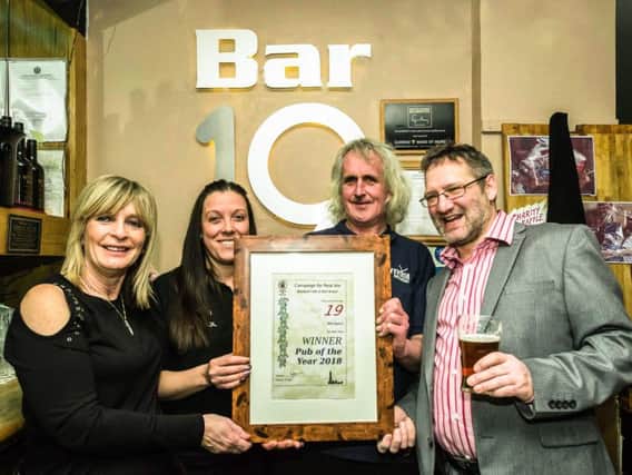 Blackpool Fylde and Wyre CAMRA Branch Chairman Rob Wheatley, right, presents the Pub of the Year award to landlord Lee Rawlings and his staff Sharon and Kelly.