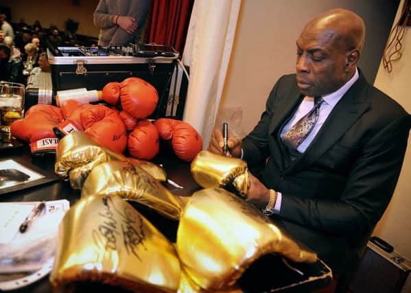 Frank Bruno signs boxing gloves for the charity auction during his appearance at St Annes Ex-Servicemen's Club