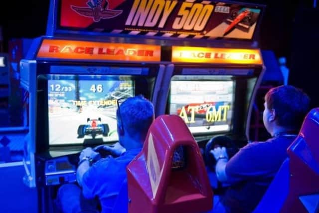 Enthusiasts enjoy the arcade games at Play Expo
