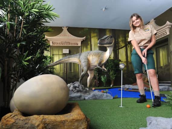 Beth Tobin plays at the new dinosaur-themed golf attraction at Blackpool Tower