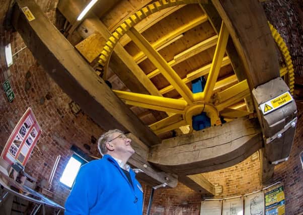Volunteer Geoff Pope surveys the workings inside Little Marton Windmill
