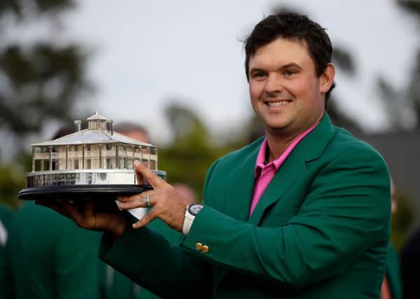 Patrick Reed holds the championship trophy