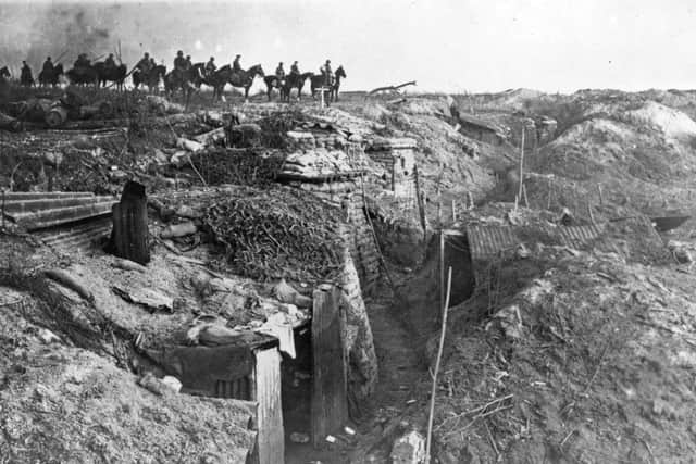 An abandoned British trench which was captured by the Germans; in the background, German soldiers on horseback