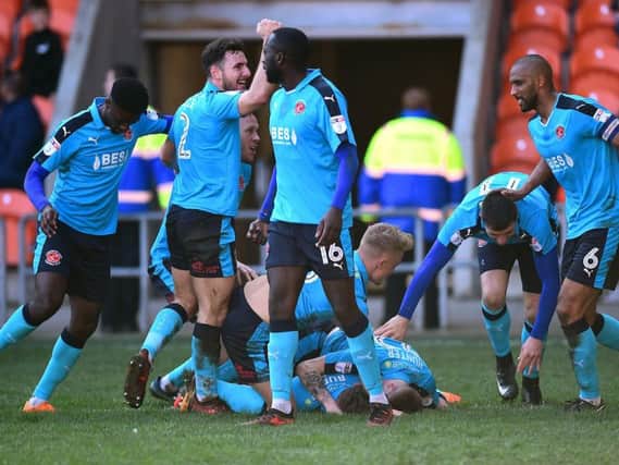 Fleetwood's Wes Burns is mobbed by his team mates after opening the scoring at Blackpool