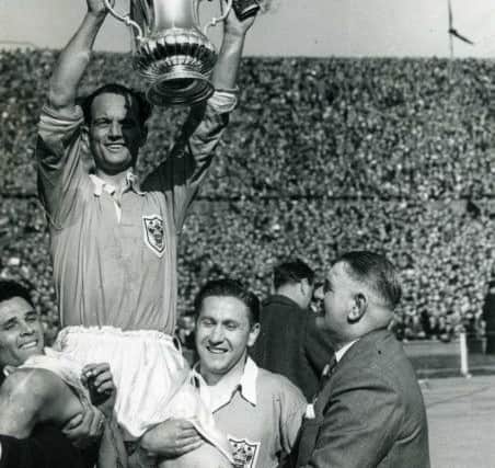 Blackpool celebrating winning the 1953 FA Cup Final
Harry Johnston hoists the FA Cup aloft on the shoulders of Stan Mortensen (right) and Bill Perry while the Blackpool manager Joe Smith looks on
