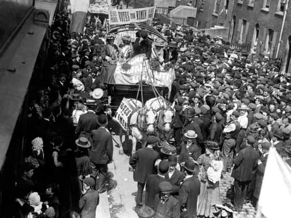 Crowds lining the streets as they watch suffragettes, from left, Emmeline Pankhurst, Mary Jane Clark (Emmelines sister), the driver, Charlotte Marsh and Jessie Kelly pass by following their release from Holloway Prison