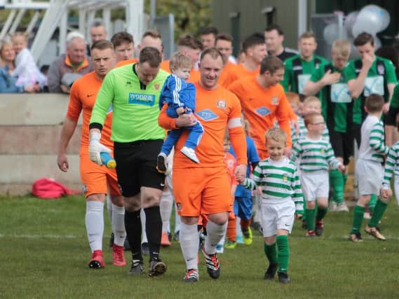 Jamie Nay leads out his AFC Blackpool side carrying son Arthur at Saturday's fundraiser   Picture: IAN DAVIES