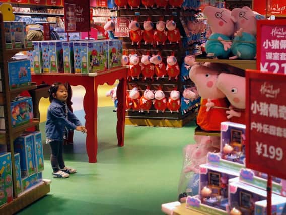 A child reacts to the Peppa Pig toys on display for sale