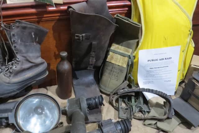 A display of items used in an air raid shelter, including boots, a water bottle, search light and harness from Lancashire historian John Higginson's collection