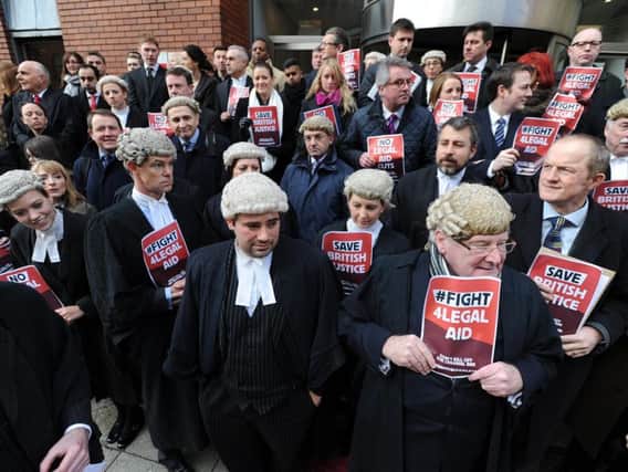 Barristers and lawyers gather outside the Leeds Combined Court during an unprecedented national walk out in protest against cuts in fees for legal aid. It was the first ever action of its kind by barristers.