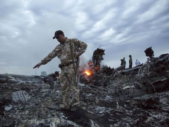 People walk amongst the debris at the crash site of the passenger plane near the village of Grabovo, Ukraine.
